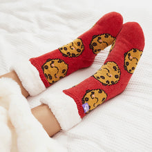 Load image into Gallery viewer, The Foozie™ Cookie Red slipper socks, crossed feet on a white bed with the sherpa cuffs folded down